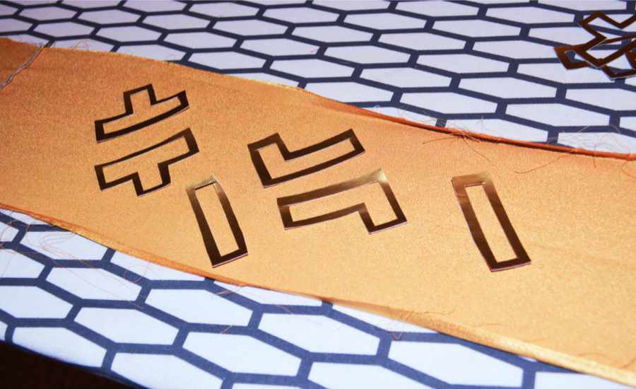 shiny gold details in the geometric shapes against a dull gold sash being prepped for ironing